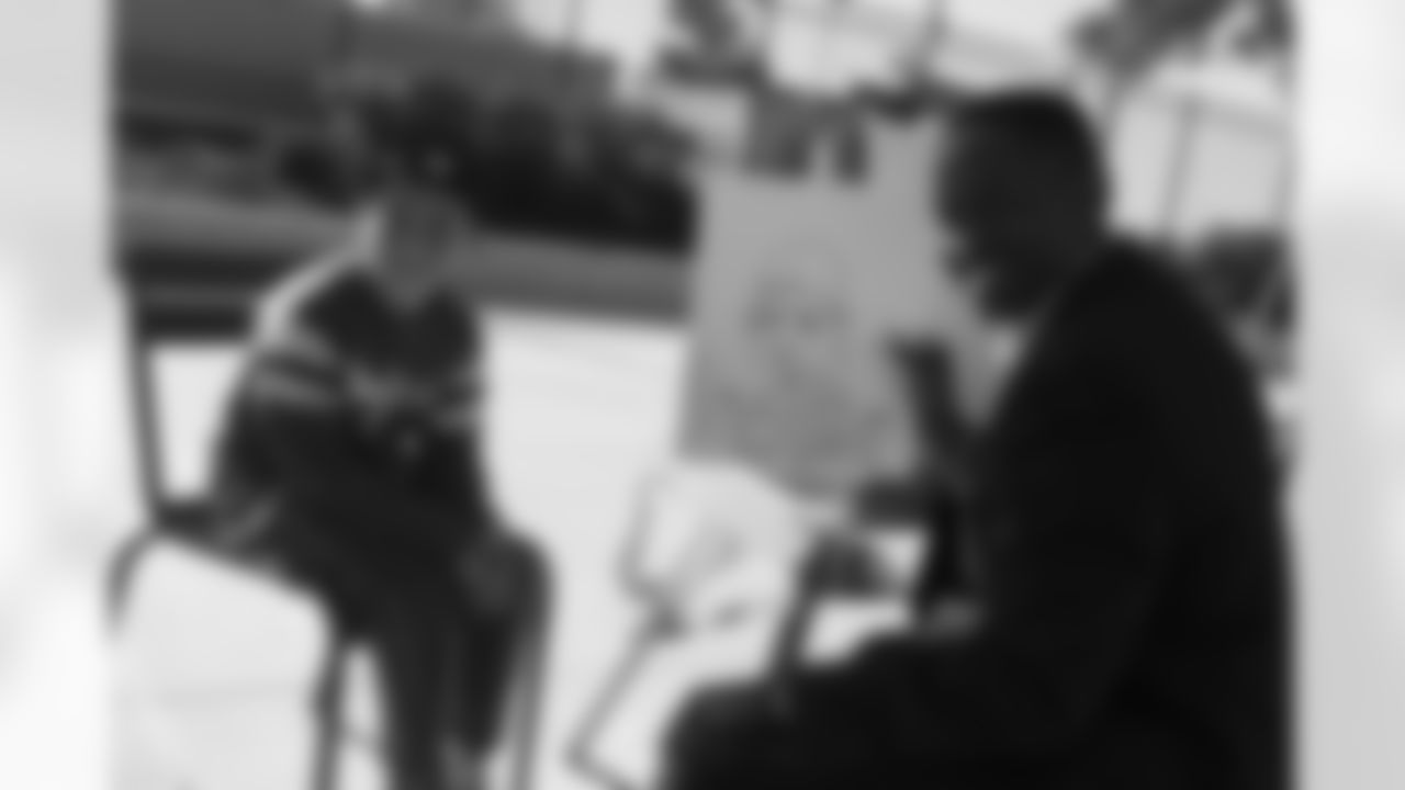A young fan smiles with the artist who's about to hand over his just-sketched caricature portrait.