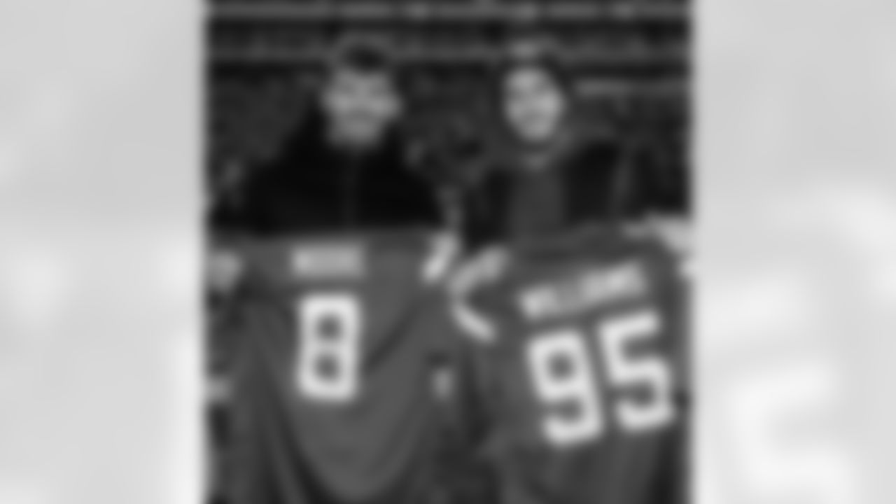 Antoine Griezmann and Koke receive signed jerseys from WR Elijah Moore and DL Quinnen Williams.