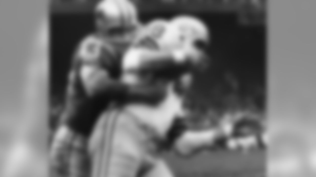 Green Bay Packers tight end Ron Kramer (88) is wrapped up by Detroit Lions safety Gary Lowe (43) during an NFL game in Detroit, Nov. 22, 1962, Thanksgiving Day. The Lions defeated the Packers 26-14. (AP Photo/Vernon Biever)