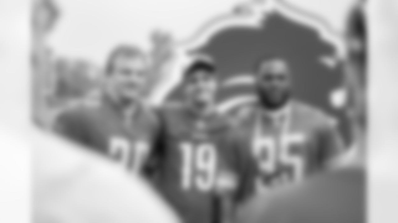 A fan getting their photo taken with Lions Legend Cory Schlesinger (30) and Lions Legend Joique Bell (35) during Lions Training Camp at the Training Facility in Allen Park,MI on August 5, 2022. (Steven Stark/Detroit Lions)