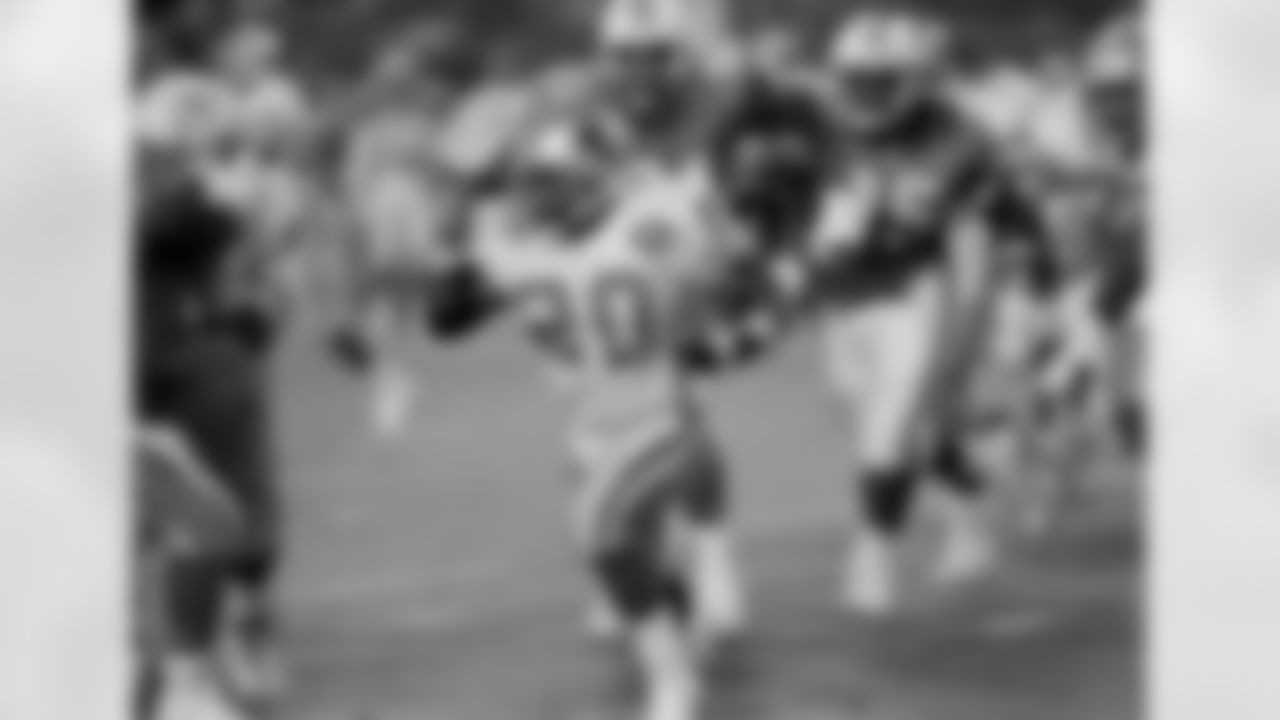 Detroit Lions running back Barry Sanders (20) runs in first quarter action as he is pursued by Jeff Cross (91) of the Miami Dolphins at Joe Robbie Stadium in Miami, Fla., Dec. 25, 1994. (AP Photo/Wayne Fleisher)