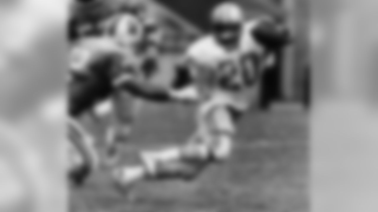 Detroit Lions' Billy Sims tries to elude the grasp of Tampa Bay Buccaneer defender Scot Brantley in the second quarter but Sims was brought down after a short run in Tampa, Florida, Sept. 16, 1984. Brantley is No. 52 at left. (AP Photo/Fred Fox)