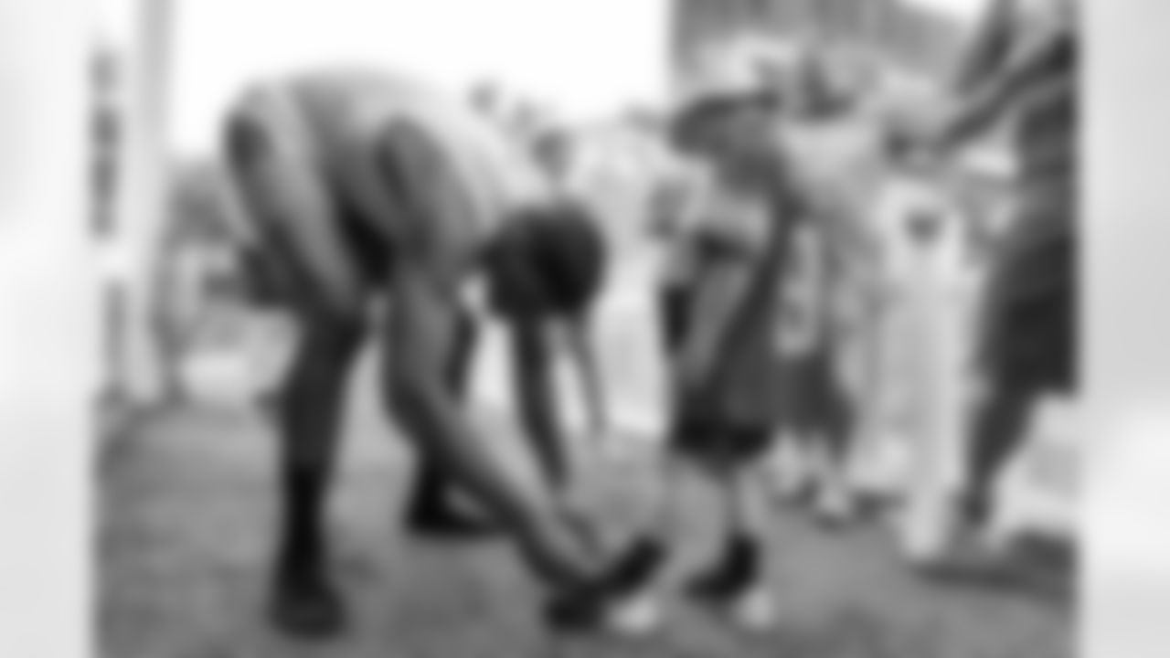 Detroit Lions wide receiver DJ Chark (4) tying a fans shoe before getting a photo together during Lions Training Camp at the Training Facility in Allen Park,MI on August 3, 2022. (Steven Stark/Detroit Lions)