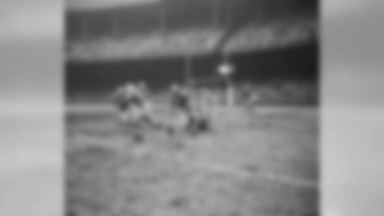 Fred Cone, (66) Green Bay Packers fullback cuts around his left end to advance from his own eighteen yard line to the forty-three in third quarter of game with Detroit Lions on Nov. 22, 1951 in Detroit. The Packer player leading interference for Cone is unidentified. James Smith (40) of the Lions is at left. (AP Photo/Preston Stroup)