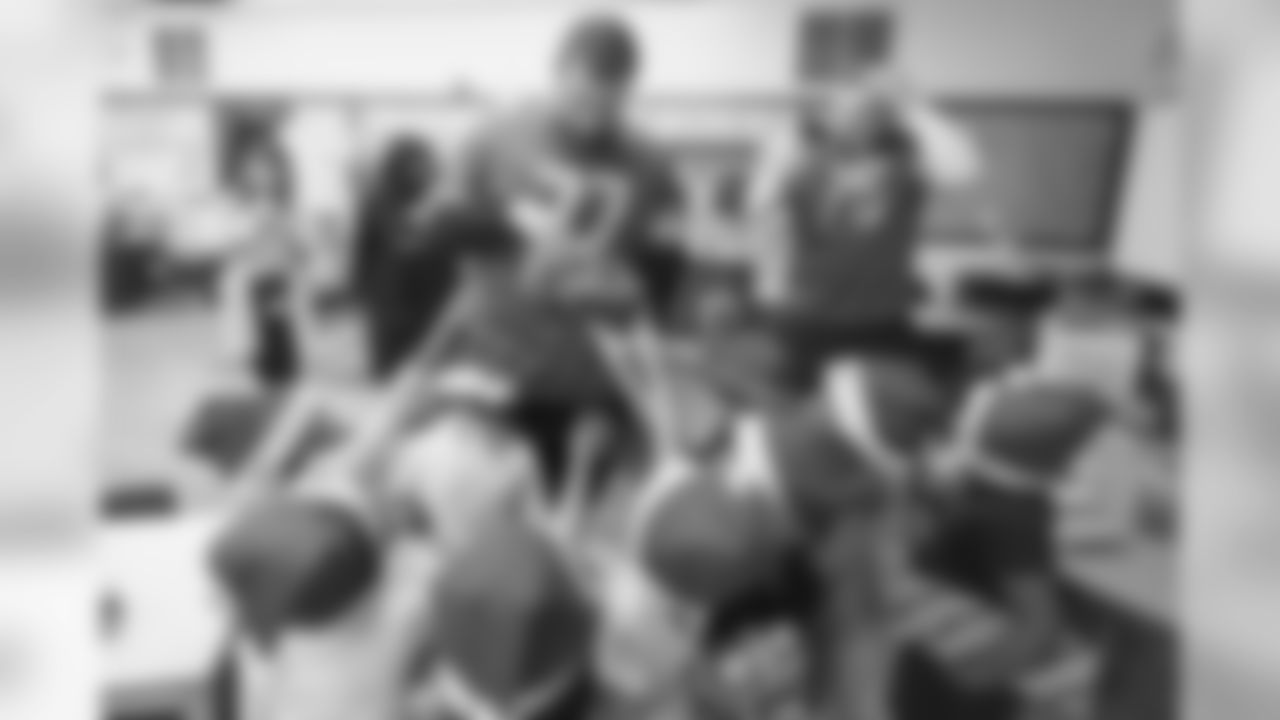 Former Detroit Lions guard T.J. Lang and Detroit Lions offensive lineman Frank Ragnow (77) distribute gifts to students at Mary McLeod Bethune Elementary-Middle School Tuesday, Dec. 10, 2019 in Detroit.