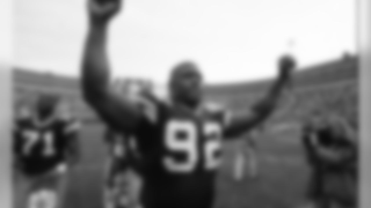 A triumphant Reggie White puts his hands in the air as he marches off the field after a 28-10 win over the Ravens on Oct. 25, 2005.