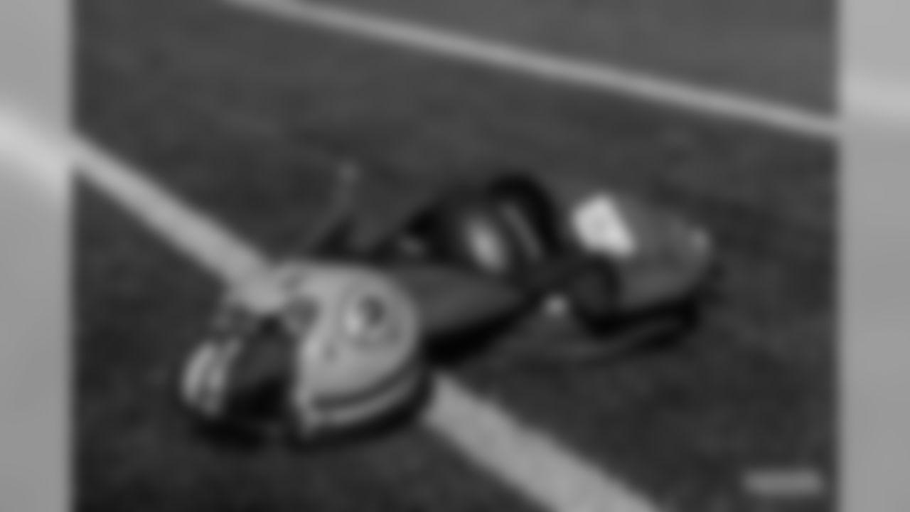 A Packers helmet rests next to footballs