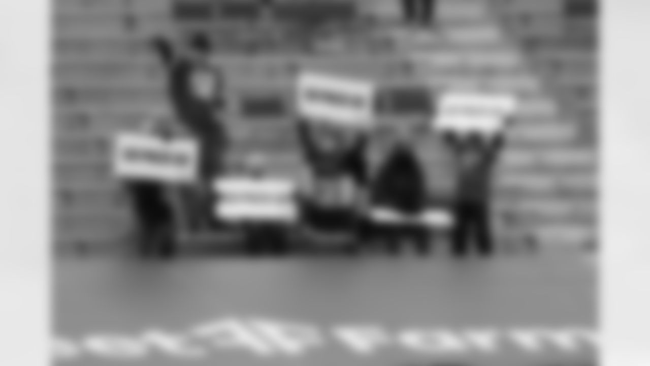Green Bay Packers fans hold signs in the stands during an NFL Divisional Round playoff game against the Los Angeles Rams on Saturday, January 16, 2021 in Green Bay, Wisconsin.