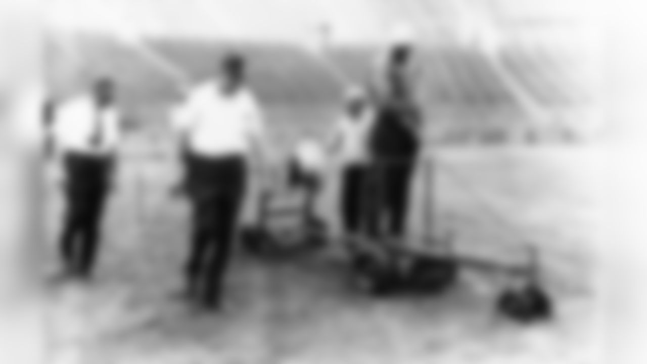 Electrical cables designed to keep the turf from freezing are laid in Lambeau Field on June 15, 1967. Watching workmen place cable are Packer Coach Vince Lombardi, with tie, and architect John Harrington. The cables allowed for football to be played year-round. The Packers won Super Bowl II that year and split the Packers-Vikings series 1-1.
