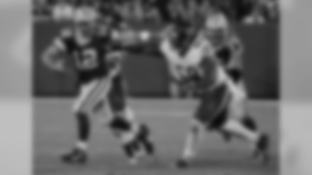 QB Aaron Rodgers tries to get away from Bears DT Henry Melton by using a stiff arm.