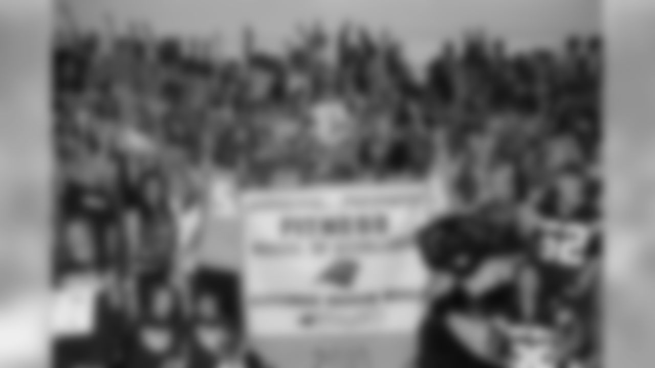 Beason and Davis display the championship banner with sixth graders from Alexander Graham Middle School.