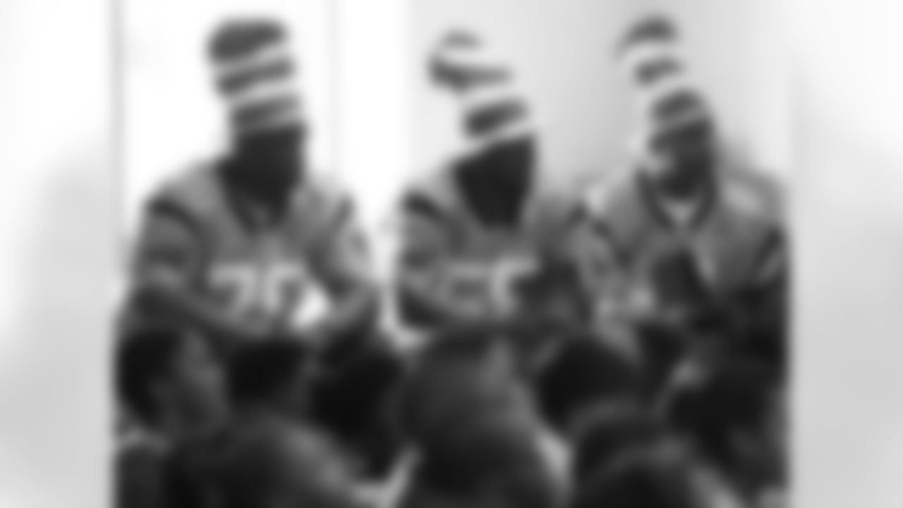 Travelle Wharton, Thomas Davis and Kenneth Moore listen in their "Cat in the Hat" headwear.