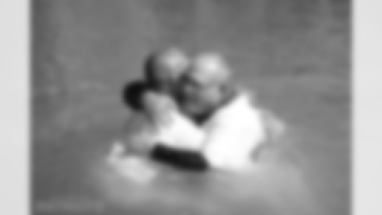 Aeneas Williams and a pastor hug after performing several baptism in the Jordan River.