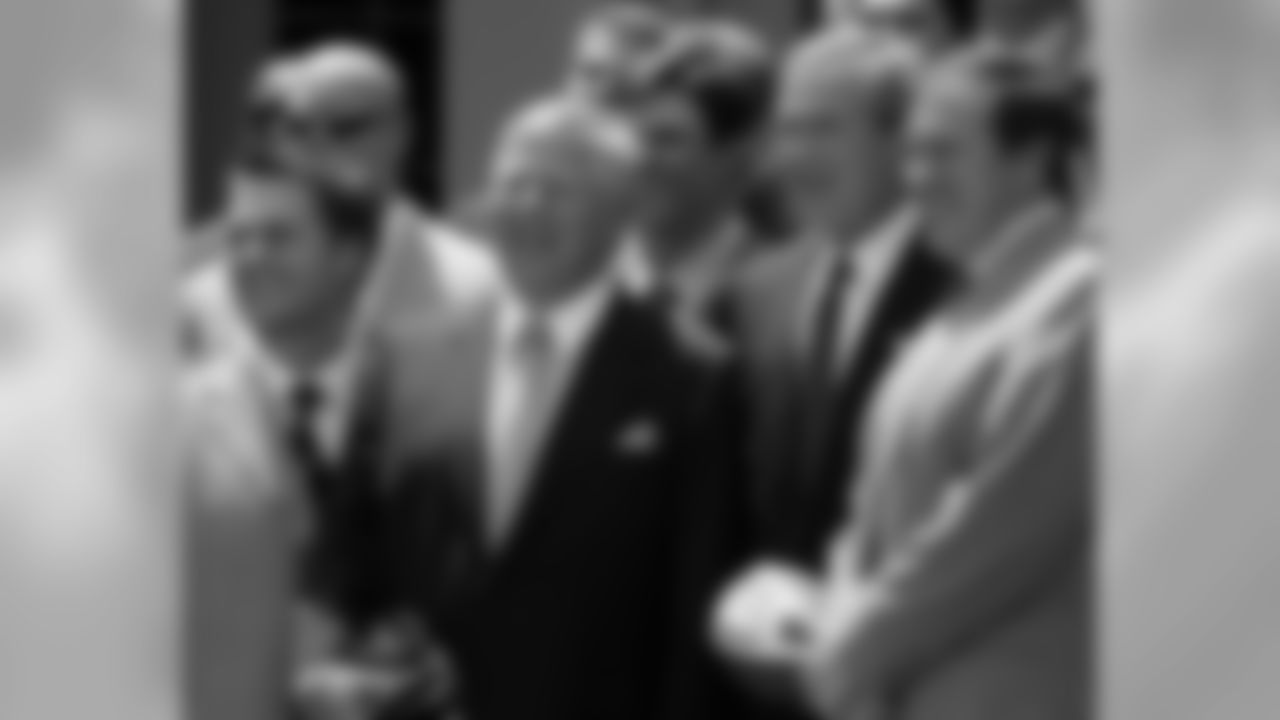 President Bush poses with Patriots owner Robert Kraft, left, and their head coach Bill Belichick, right, as he met with the 2004 National Football League champion New England Patriots, Monday, May 10, 2004, in the Rose Garden of the White House. At left in front row is quarterback Tom Brady. Others are unidentified. (AP Photo/Ron Edmonds)
