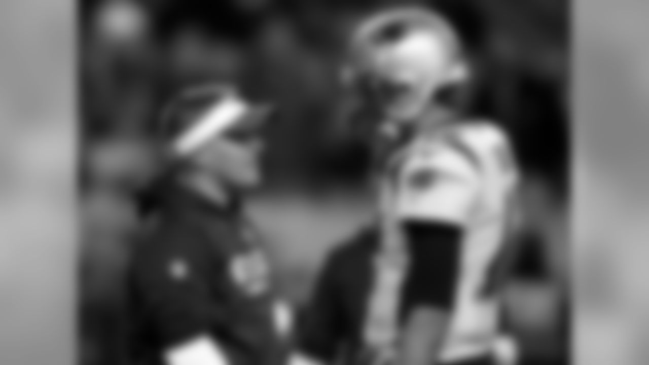 New England Patriots offensive coordinator Josh McDaniels talks with Tom Brady prior to an NFL football game against the Denver Broncos, Sunday, Nov. 12, 2017, in Denver. (AP Photo/David Zalubowski)