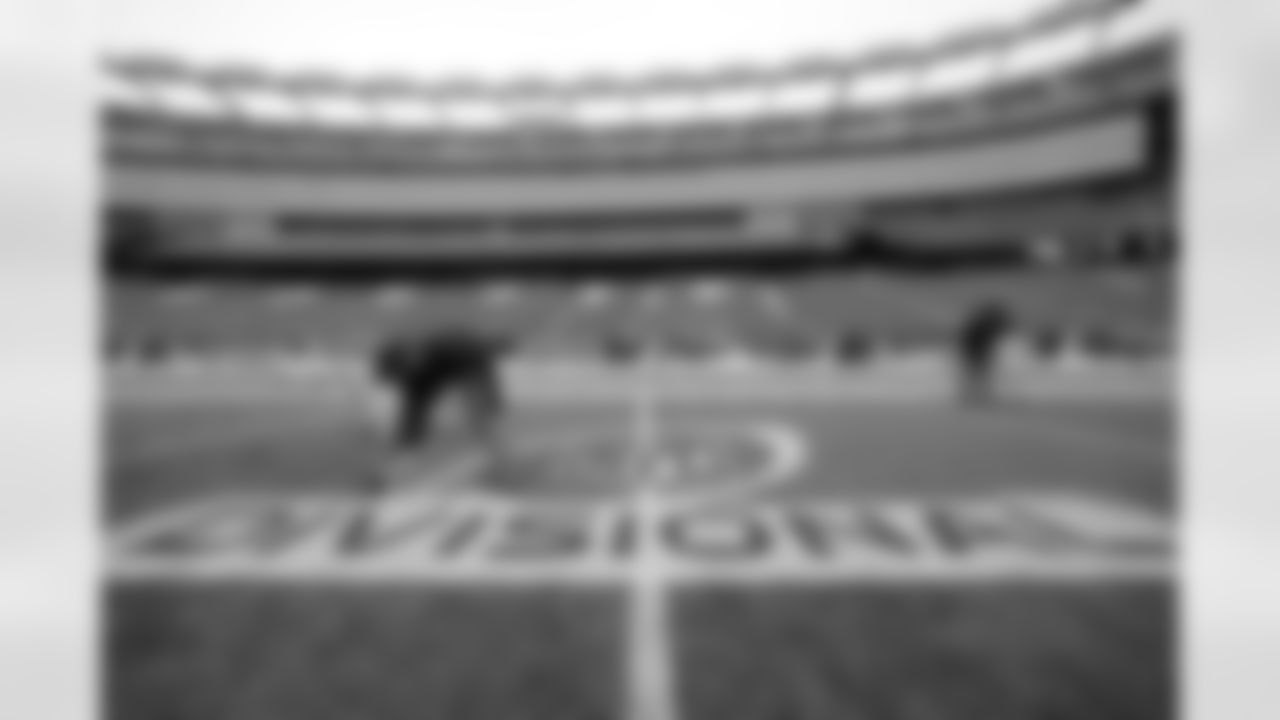 Gillette Stadium field crew foreman Joshua Bergeron, of Providence, R.I., left, applies paint to an NFL football AFC championship divisional round logo, Monday, Jan. 8, 2018, at Gillette Stadium in Foxborough, Mass. The Patriots are scheduled to host the Tennessee Titans in the AFC divisional round game, Saturday, Jan. 13, 2018, in Foxborough. (AP Photo/Steven Senne)