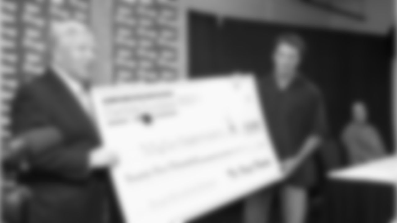Robert Kraft, on behalf of the New England Patriots Charitable Foundation presents Doug Flutie with a check for $22,000 for the Doug Flutie Jr. Foundation for Autism. The 22 represents Flutie's both stints with the Patriots, each time wearing the number #2. Flutie announced his retirement during a ceremony at Gillette Stadium. 5/15/2006 Photo by Keith Nordstrom