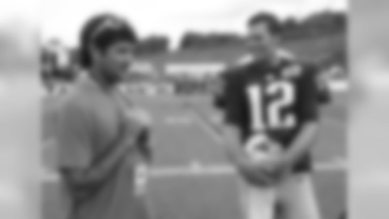 New England Patriots quarterback Tom Brady (12) talks with pro golfer Bubba Watson after a joint practice between the Patriots and New Orleans Saints at the Saint's NFL football training camp in White Sulphur Springs, W.Va., Thursday, Aug. 20, 2015.  (AP Photo/Steve Helber)