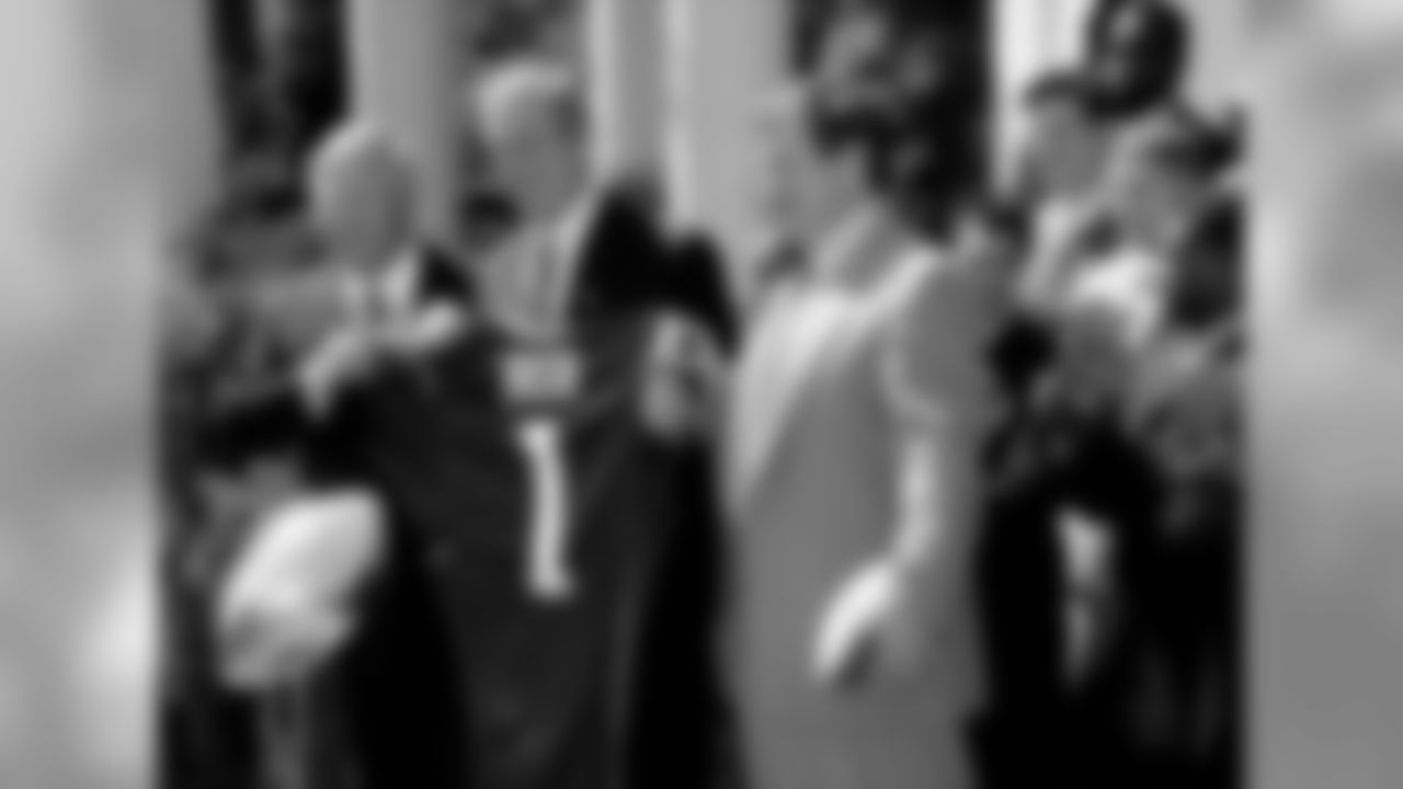 President Bush shows off the jersey he was given from the New England Patriots, as he is flanked by Robert Kraft, left, owner of the Super Bowl champions, and Patriots coach Bill Belichick, during ceremonies in the Rose Garden of the White House, Tuesday, April 2, 2002. Members of the Patriots at right are unidentified. At left foreground is the Super Bowl Trophy. (AP Photo/Doug Mills)