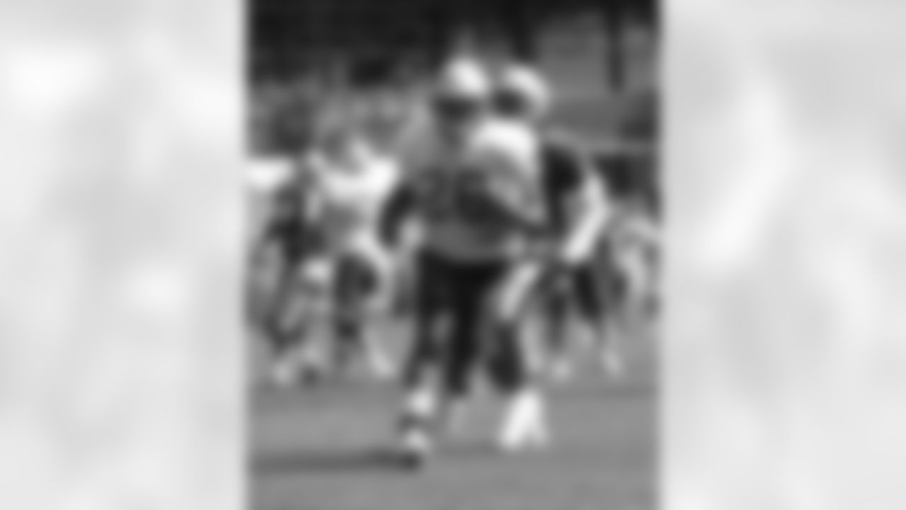 Running back Corey Dillon(28) breaks through the line as defensive back Hank Poteat(32) pursues during the morning practice on Wednesday, August 16. Photo by Chris Ferreira