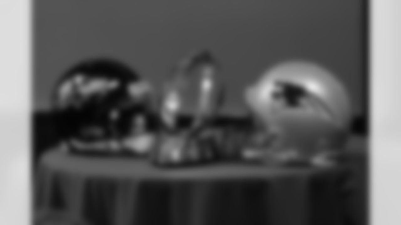 Helmets for both the New England Patriots and Baltimore Ravens are present with the Lamar Hunt trophy