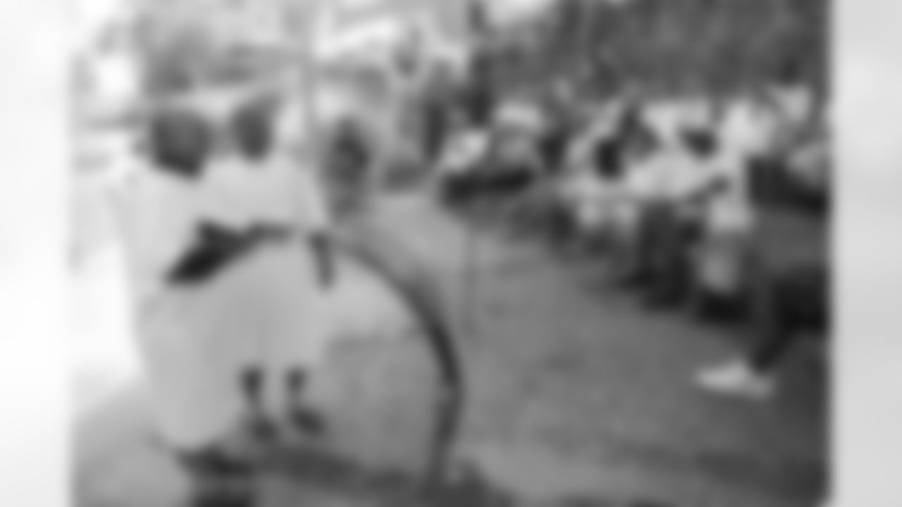 A pastor and Aeneas Williams read before many members of the group are baptized in the Jordan River.