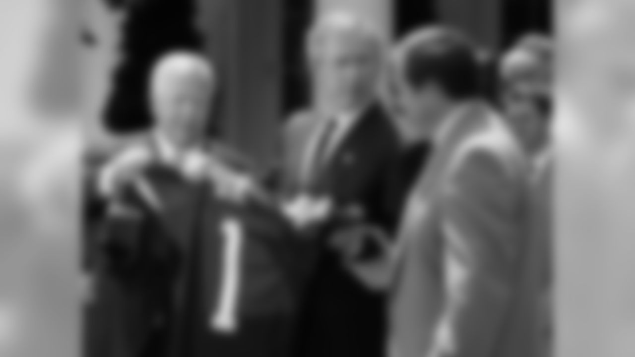 * FILE * President Bush is given a team football jersey by New England Patriots owner Robert Kraft, left, and head coach Bill Belichick, right, as he met with the 2004 National Football League champion New England Patriots, in this May 10, 2004 file photo in the Rose Garden of the White House. Since August, President Bush has welcomed to the White House just one foreign leader _ the largely U.S.-installed interim prime minister of Iraq. No other meetings are on the horizon until Bush goes to Chile in late November for a gathering of Asia-Pacific leaders. The same period last fall was quite a different story: the president played host, in the Oval Office and at the Camp David presidential retreat, to leaders from seven nations while aides put out word of several more mini-summits to come. That disparity is just one example of how official presidential duties have been pared to a minimum as Bush concentrates on his super-close, bare-knuckles campaign to occupy the White House for another four years. (AP Photo/Ron Edmonds, Files)