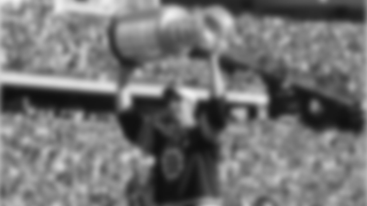 Boston Bruins captain Zdeno Chara holds up the Stanley Cup on the field prior to the New England Patriots facing the New York Jets in an NFL football game in Foxborough, Mass., Sunday, Oct. 9, 2011. (AP Photo/Elise Amendola)