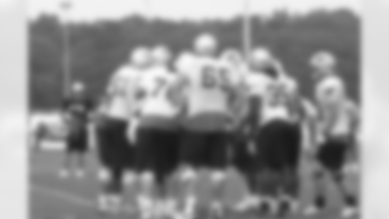 Evening practice comes to an end as players, such as Laurence Maroney(39), Wesly Britt(65) and Stephen Neal(61) gather in a huddle on Day 2 of Training Camp. 7/29/2006 Photo by Elizabeth Propper