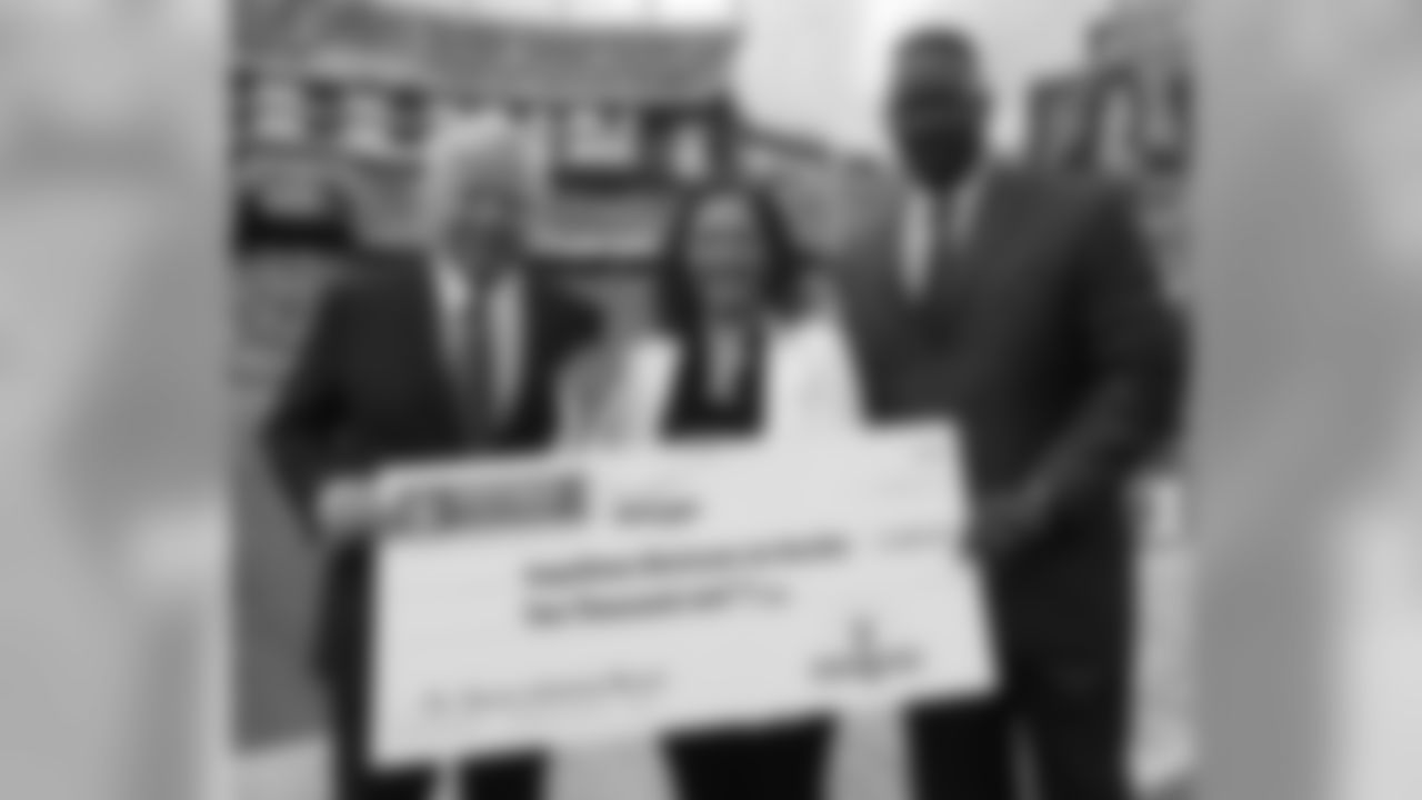New England Patriots owner Robert Kraft, left, honors Dr. Vanessa Calderón-Rosado, CEO of Inquilinos Boricuas en Acción, with an NFL Hispanic Heritage Leadership Award Winner before an NFL football game between the Patriots and the Oakland Raiders Sunday, Sept. 21, 2014, in Foxborough, Mass. At right is Patriots executive director of community affairs Andre Tippett.