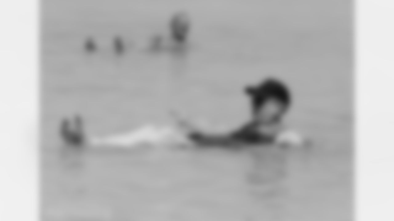 Roger Staubach and Joe Montana (background) float comfortably in the Dead Sea.