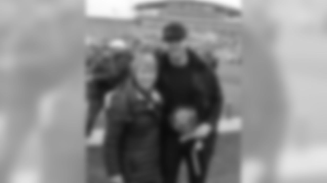Julian Edelman stands along the sidelines of Dix Stadium with President Beverly Warren during a break in the action to receive his induction into the athletic "Varsity K" Hall of Fame.