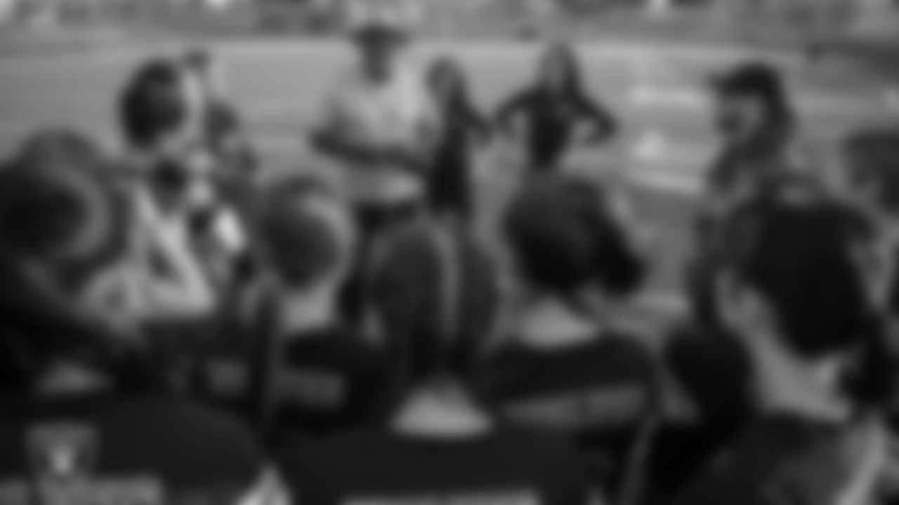 Las Vegas Raiders alumnus Roy Hart talks to Basic High School's girls flag football team after presenting their coach, Ken Ward, with the Tom Flores High School Coach of the Week award.