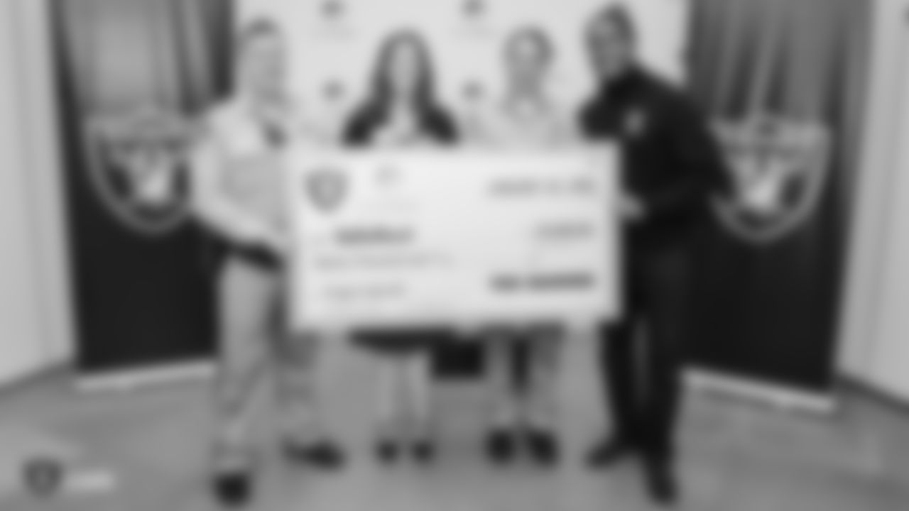 Raiders alumnus Leo Gray presents a grant for Project Safe 417 (PS417), a program provided by SafeNest in cooperation with Las Vegas Metropolitan Police Department.