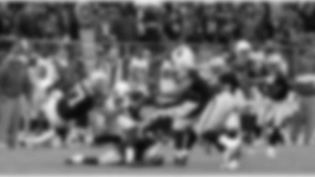 DE Matt Shaughnessy gets his hands around the ball carrier to bring him down.