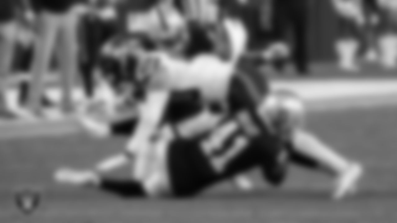 Las Vegas Raiders linebacker Javin White (53) and defensive back De'Vante Bausby (41) makes a tackle during the preseason home game against the Seattle Seahawks at Allegiant Stadium.
