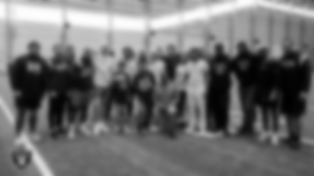Ruben Minjares and Sergio Robles from the Make-A-Wish Foundation pose for a photo with the Las Vegas Raiders defense during a visit to Intermountain Healthcare Performance Center.