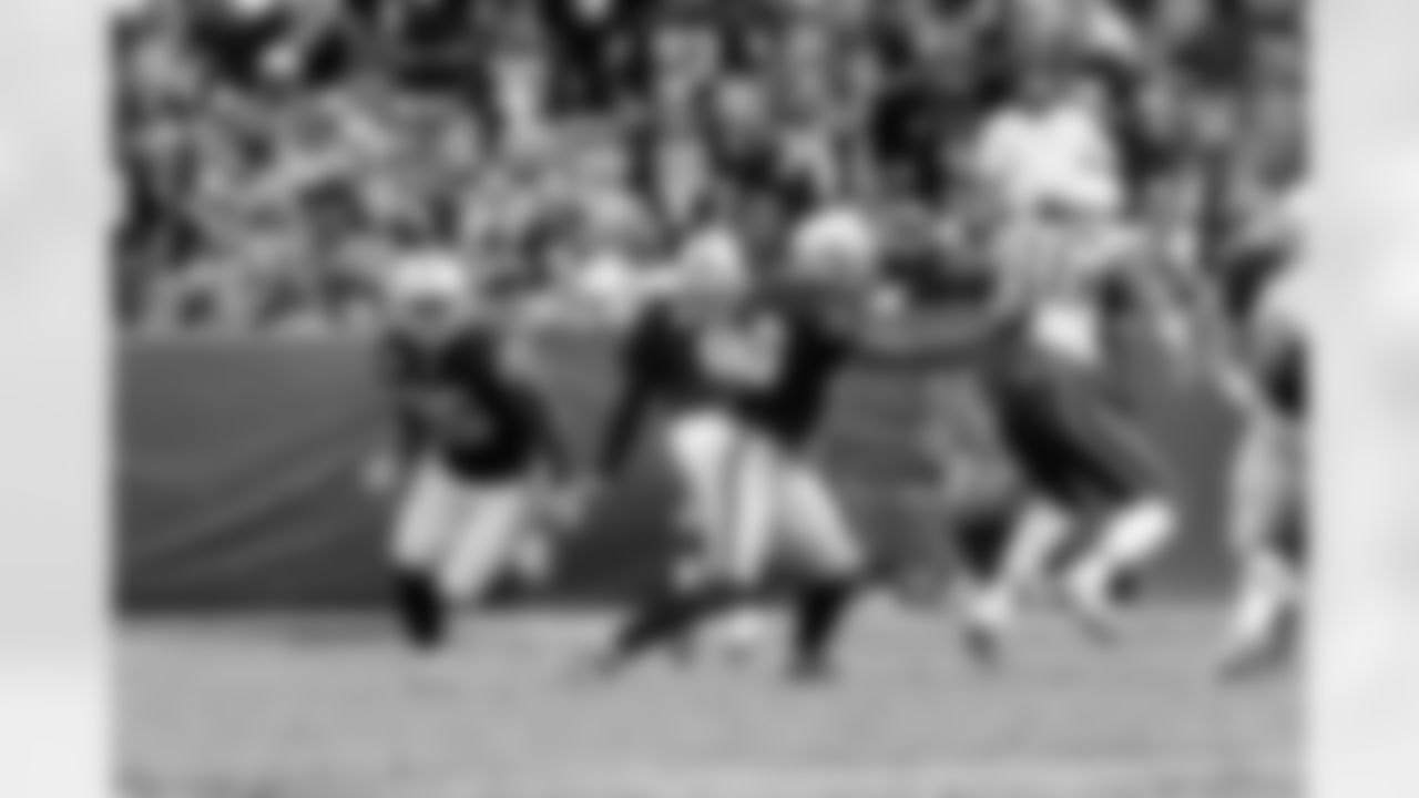 P Shane Lechler punts the ball as RB Rock Cartwright heads up the field.