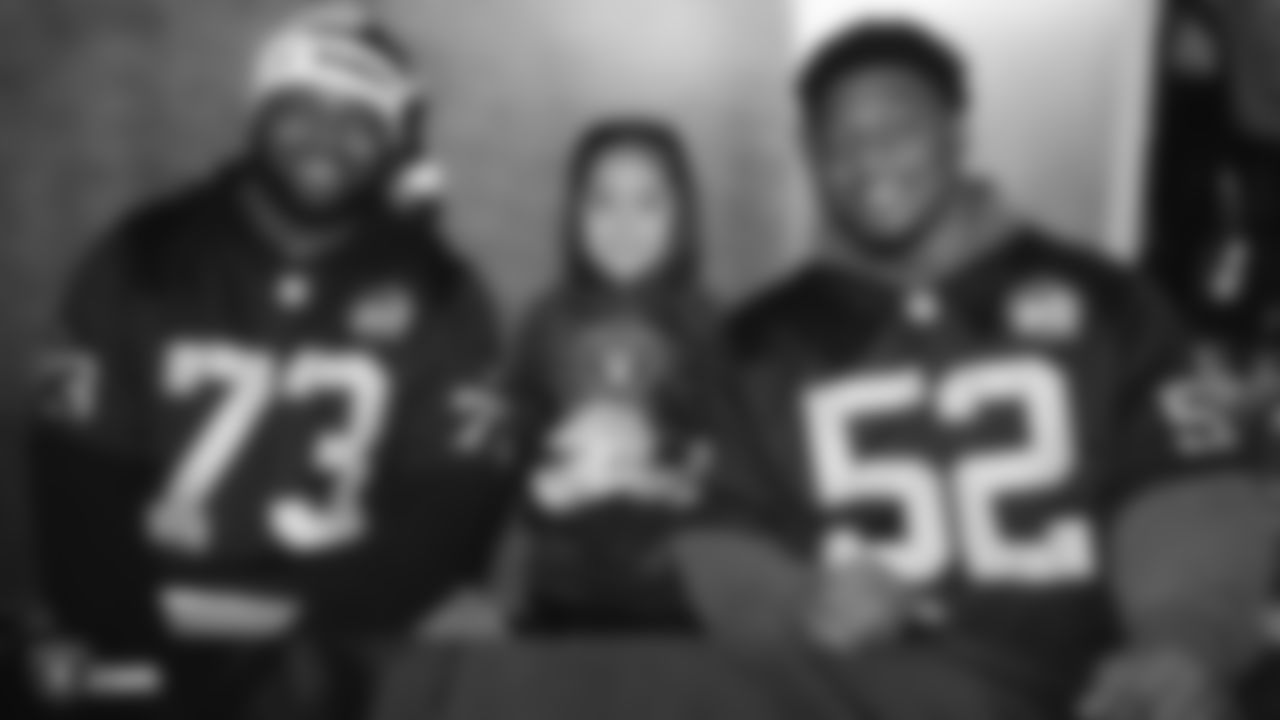 Raiders defensive tackle Maurice Hurst (73) and linebacker Marquel Lee (52) pose for a photo with a young fan during the Raiders Foundation's Toys for Tots drive.
