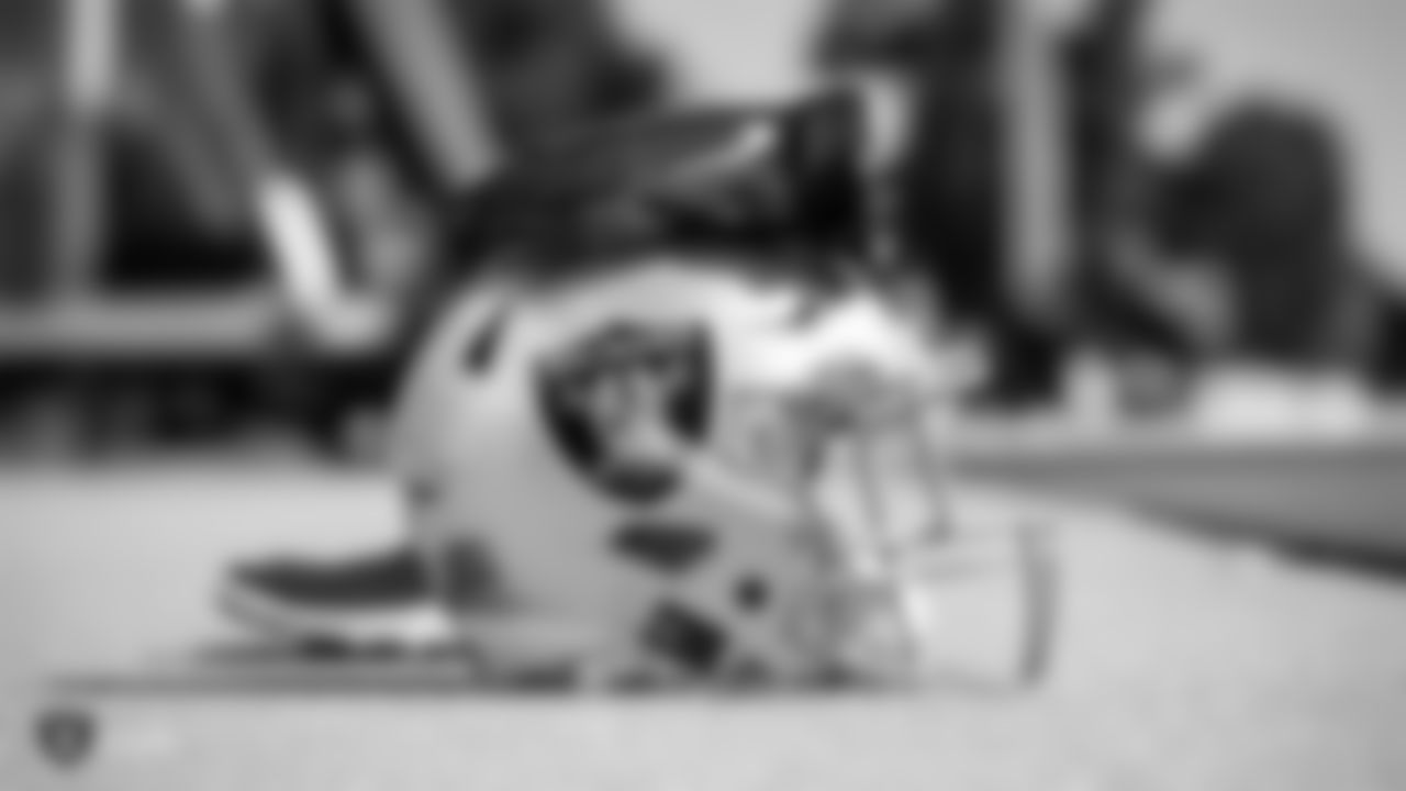 A Raiders helmet and gloves on the field for practice.