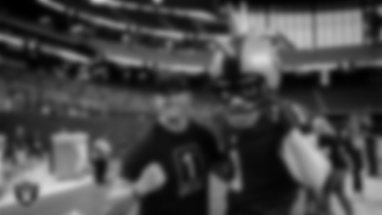 A first responder poses with Raider Rusher during a Thank You, First Responders night.