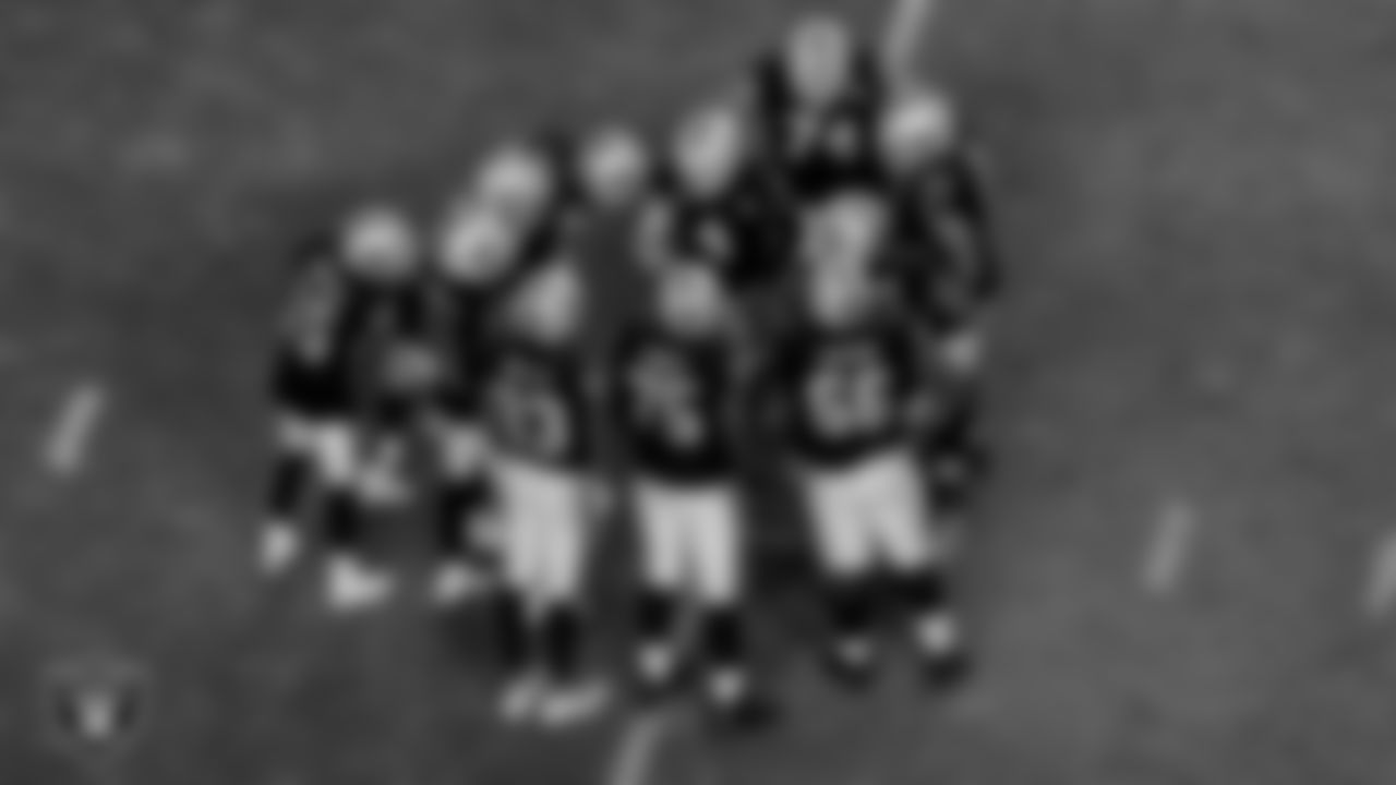 The Las Vegas Raiders offense huddles during the regular season game against the Kansas City Chiefs at Allegiant Stadium.