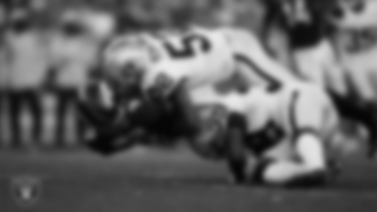 Las Vegas Raiders linebacker Denzel Perryman (52) and cornerback Nate Hobbs (39) make a tackle during the regular season away game against the Denver Broncos.