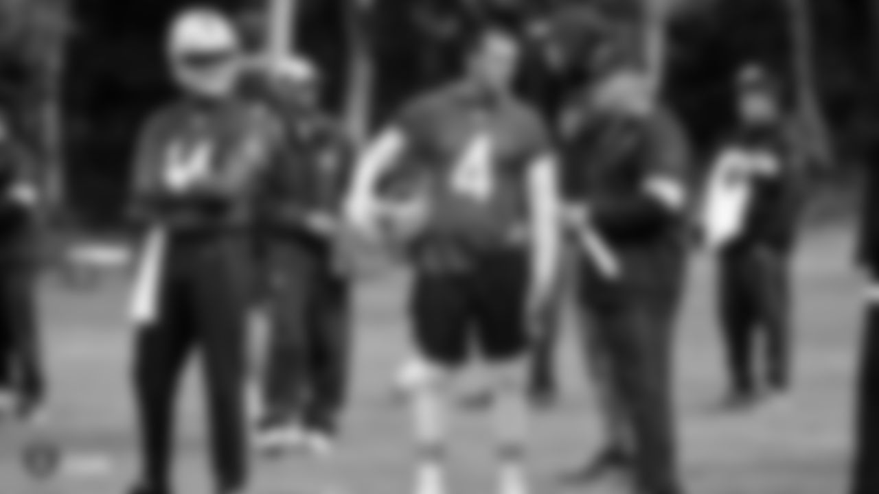Oakland Raiders quarterback DeShone Kizer (14), quarterback Derek Carr (4) and Head Coach Jon Gruden talk on the field during practice.