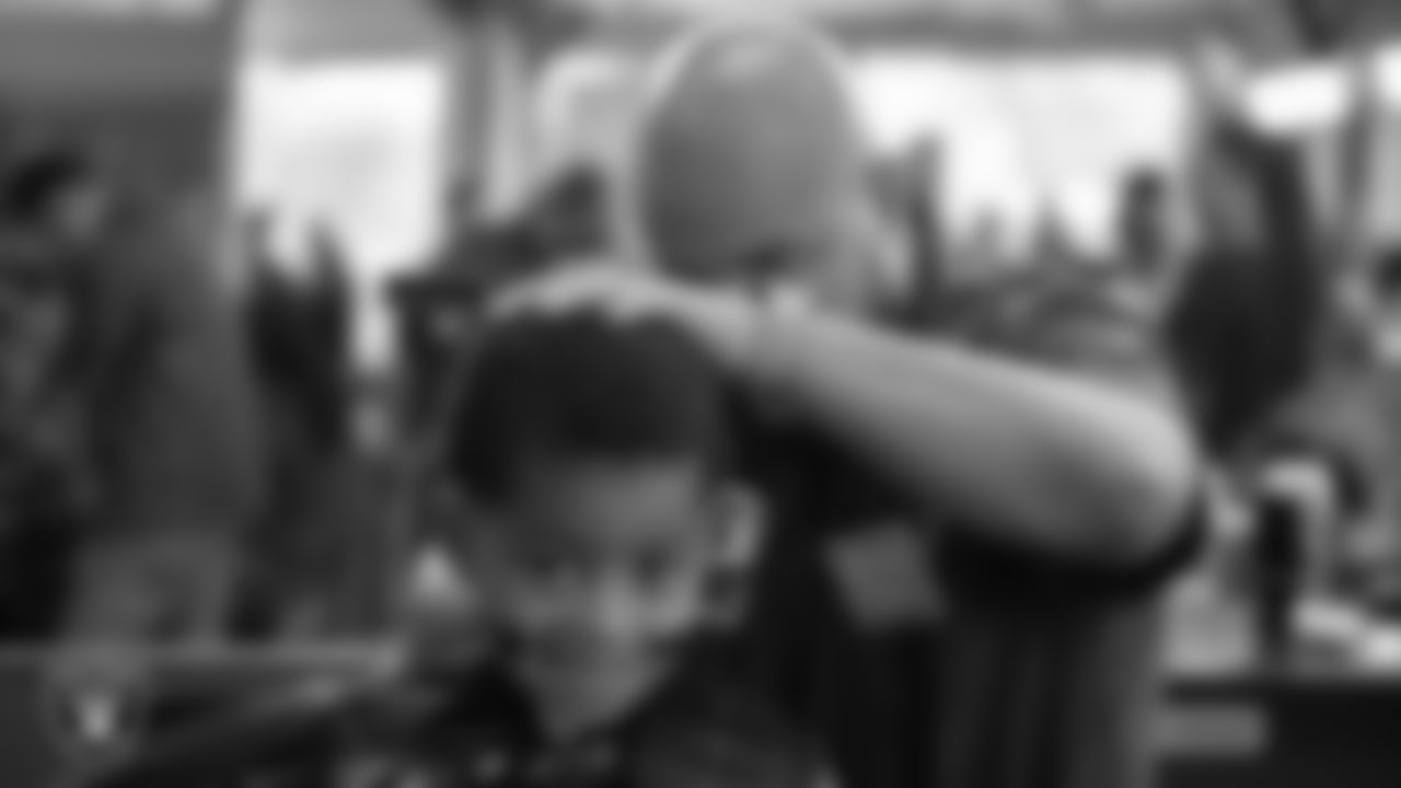 Students receive free haircuts and beautician services for the back to school season courtesy of the Las Vegas Raiders at Masterpiece Barber School.
