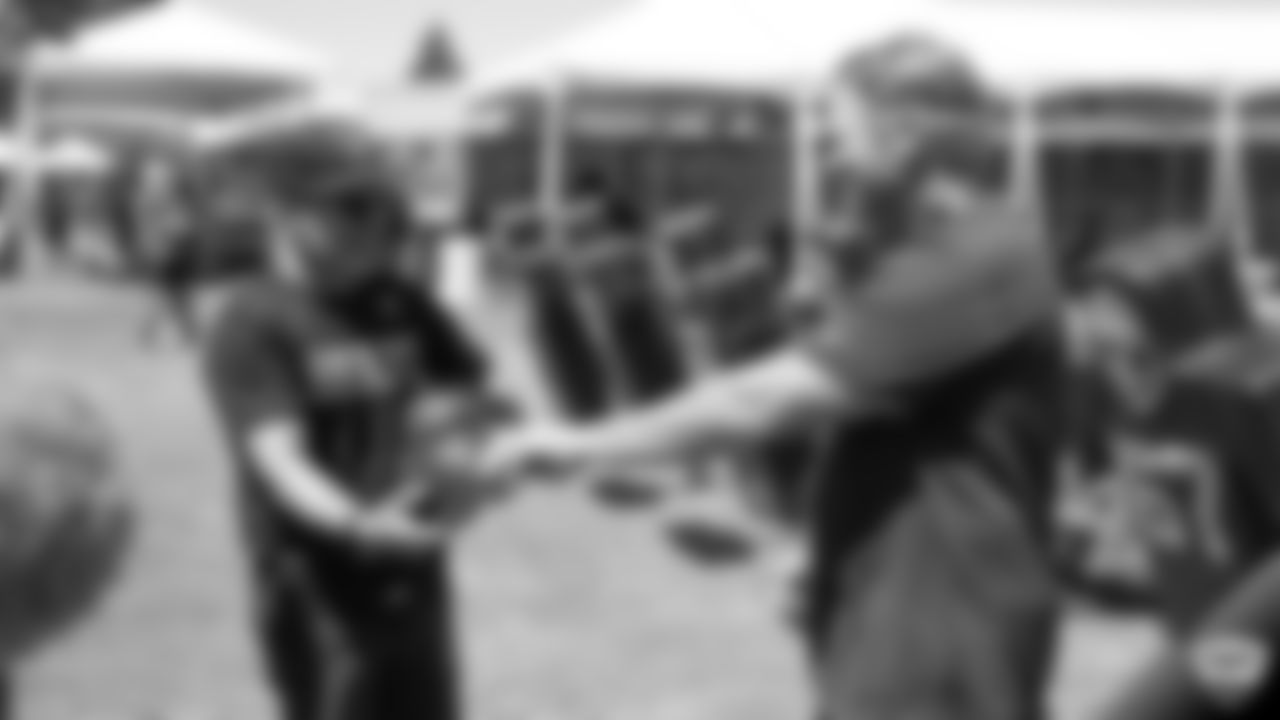 Raiders head coach Jon Gruden gives his practice-worn hat to George DeLeon, father of musical artist Bohnes, after practice at 2019 Training Camp.