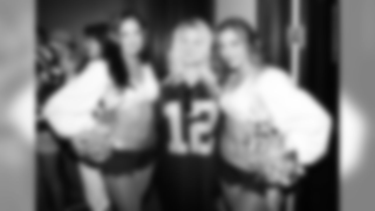Raiderettes Bess and Michelle pose for a photo with a Raiders fan.