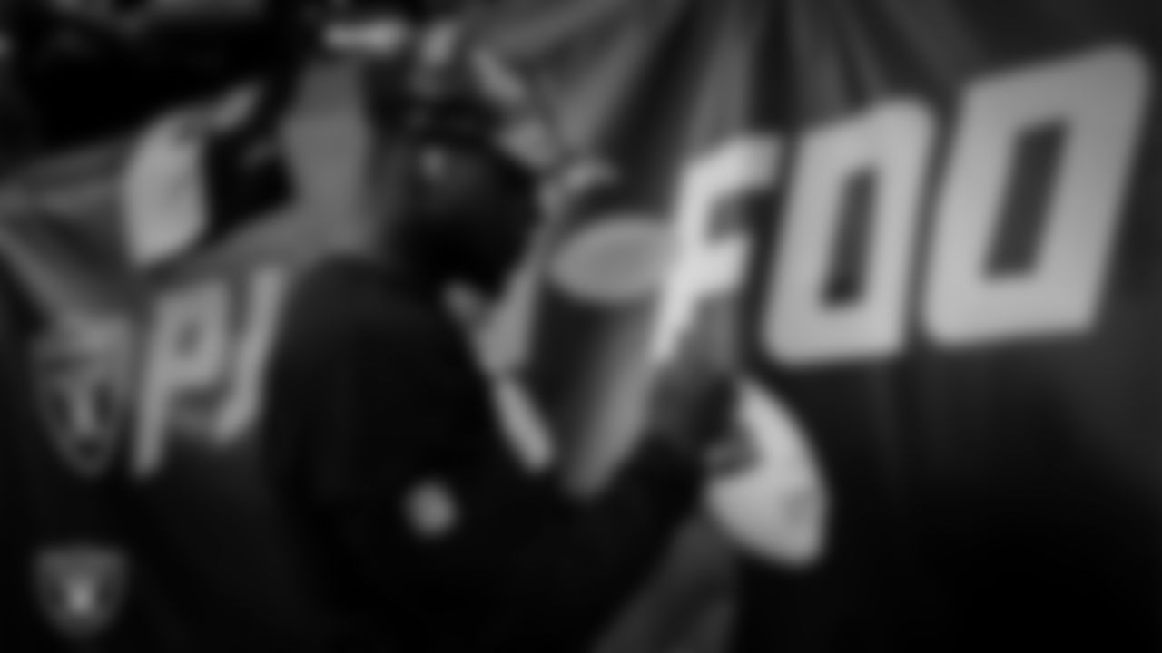 Las Vegas Raiders linebacker Jayon Brown (50) signs autographs for fans before the preseason home game against the Minnesota Vikings at Allegiant Stadium.