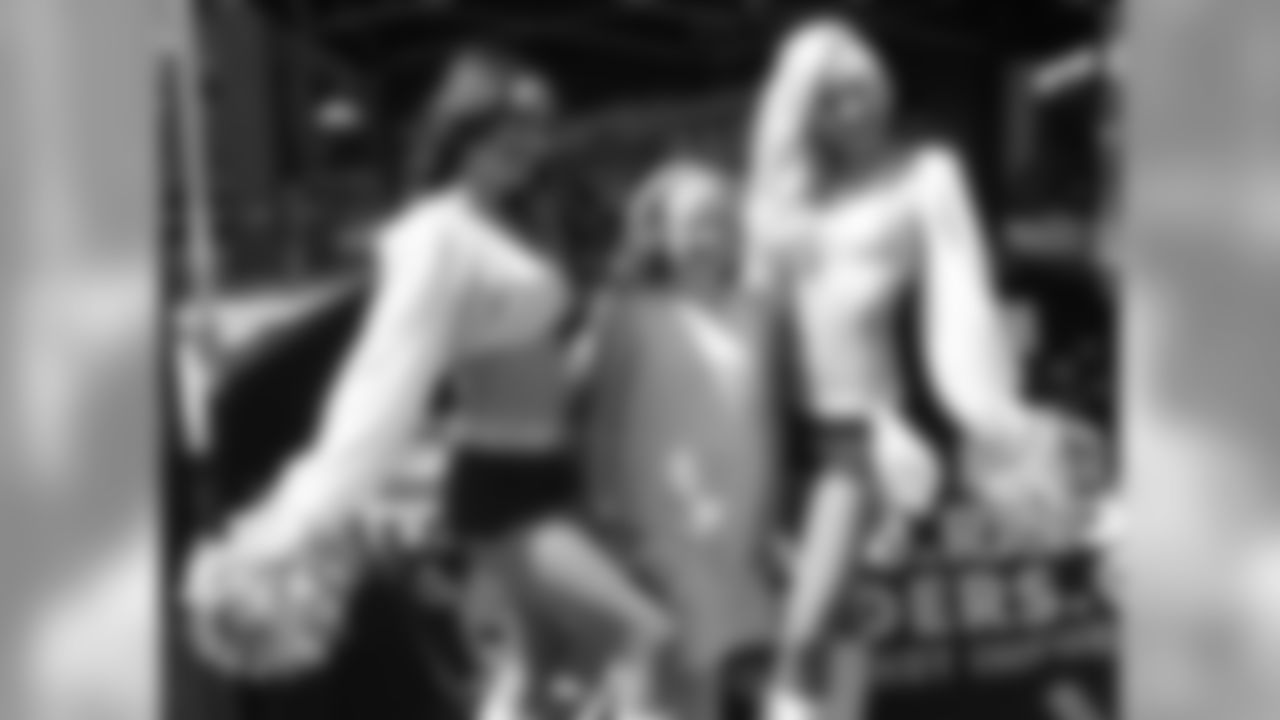 Raiderettes Cassie and Maureen pose for a photo with a fan.