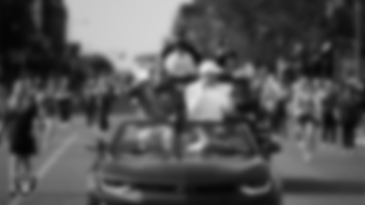 Hall of Famer Tom Flores and Las Vegas Raiders Owner Mark Davis ride in the back of a convertible during the Canton Repository Grand Parade.
